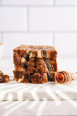 Wall Mural - Slices of Chocolate banana bread with walnuts on a marble board and ingredients on a grey neutral background