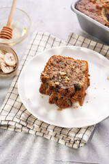 Wall Mural - Slices of Chocolate banana bread with walnuts on a checkered kitchen napkin and ingredients on a grey neutral background with creative lighting