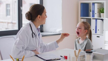 Poster - medicine, healthcare, pediatry and people concept - female doctor or pediatrician with tongue depressor checking little girl patient's throat on medical exam at clinic