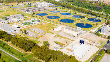 Wall Mural - Aerial view of the tanks of a sewage and water treatment plant enabling the discharge and re-use of waste water.  It's a sustainable water recycling with treatment plant.