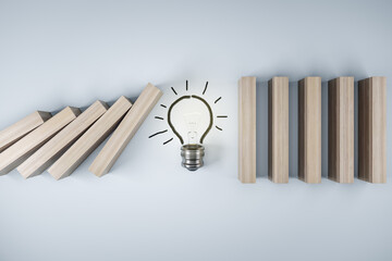 Wall Mural - Business crisis and risk protection concept with light bulb stopping wooden pieces of a domino effect on abstract light background. 3D rendering