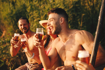 Sticker - Group of young people drinking beer by the river during the summer sunny day