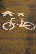 White Bycicle And Pedestrian Symbols On A Path. Pictogram Imitating Of Walking Figures, Parent And Child. Travel And Tourism Concept