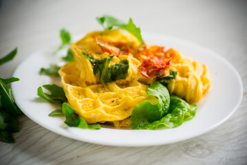 Wall Mural - Egg omelet stuffed with tomato and greens fried in the form of waffles