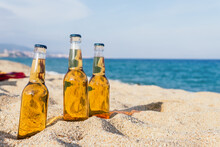 Bottles Of Beer On Sand Near Sea