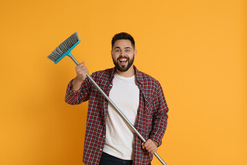 Sticker - Young man with broom on orange background