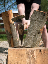 Man Splitting A Log With A Big Ax