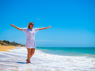 Wall Mural - Woman walking on sunny beach