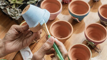 Hands Of A Latin Woman, Painting Clay Pots To Plant Succulent Plants
