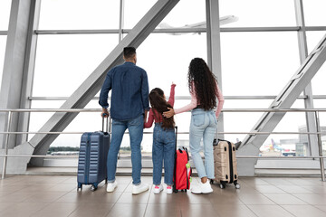 Wall Mural - Family With Daughter Looking At Plane Departure Out Of Window In Airport