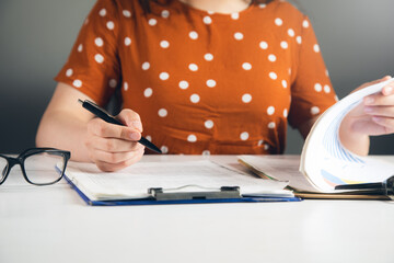 Canvas Print - Woman signing document and hand holding pen