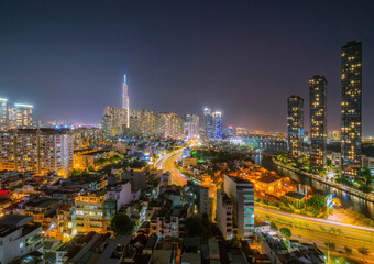 Aerial view of Bitexco Tower, buildings, roads, Thu Thiem 2 bridge and Saigon river in Ho Chi Minh city - Far away is Landmark 81 skyscraper. Travel concept.