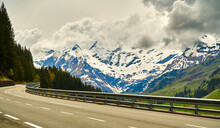 Cloudy Dachstein Mountains In Austria With The High Alpine Road In The Foreground During A Road Trip Through The Alps