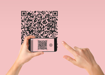 Woman scanning QR code with smartphone on pink background, closeup