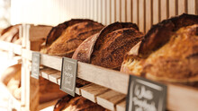 The Sourdough Bread Lies On The Shelves In The Bakery Store - A Real Rustic Artisan Bread