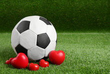 Soccer Ball And Hearts On Green Grass. Space For Text