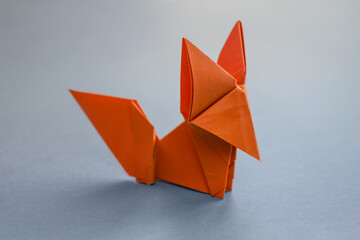 Wall Mural - orange paper fox origami isolated on a grey background