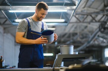 Man working in printing house with paper and paints