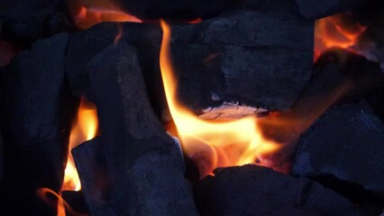 Wall Mural - slow motion speed closeup scene on burning charcoal pile with ash and flake of spark scattered blowi