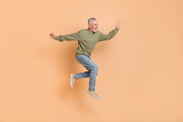 Sticker - Full size photo of cool elder grey hairdo man run wear pullover jeans shoes isolated on beige background