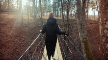 Walking On Suspension Bridge. Tourist Traveler Explore Forest Rope Bridge