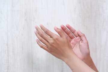 Close-up of woman's hand showing applause gesture on gray background