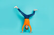 Full length photo of funky funny guy dressed orange sweater dancing walking arms isolated turquoise color background