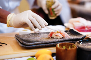 Focus on sushi while the chef is cooking.