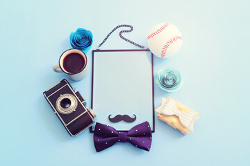 Wall Mural - Father's day concept. bow tie, funny moustache and empty frame with copy space over blue background. top view, flat lay