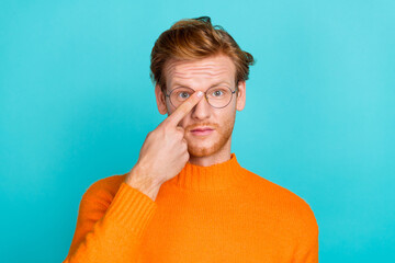 Photo of positive smart young man wear orange pullover arm adjusting spectacles isolated teal color background