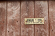beware of the dog sign on a wooden panel fence