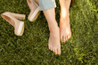 Photo of some feet resting from high heels on fresh green grass on day time. Outdoors shot in the sun light.