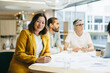 © Jacob Lund - Cheerful businesswoman sitting in a meeting with her colleagues