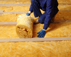 Wall Mural - Man installing thermal insulation layer under the roof