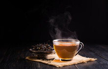 Hot Herbal Teacup And Dried Tea Leaves In A Ceramic Cup Placed On A Black Wooden Table On, Dark Background