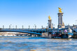     Paris, the Alexandre III bridge on the Seine, with houseboats on the river
