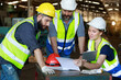 © atitaph - Male and female engineers chat with factory workers as they use machine drawings, planning for industrial maintenance
