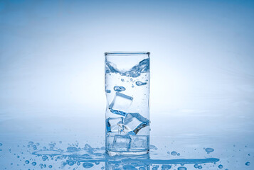 Canvas Print - Ice cube fell into the glass of water. Water splashed from the clear glass. Fresh concept