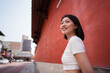 © ADDICTIVE STOCK - Young ethnic woman smiling away against red wall