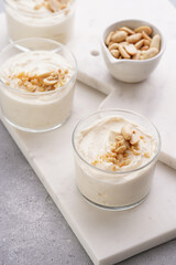 Wall Mural - Creamy dairy yoghurt dessert with mascarpone, cream cheese and peanut butter in glasses on marble tray