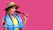© khmelev - Tourism concept. Excited young caucasian woman tourist with photo camera, isolated on pink background. Female student hipster in casual clothes and straw hat