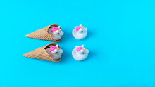 White And Pink Plastic Unicorns Coming Out Of Ice Cream Cones Against Pastel Blue Background. Minimal Surreal Concept For Summer Holidays Banner Or Card. Flat Lay. Copy Space.