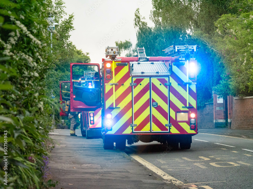 A pair of english fire engines parked at the side of the road ...