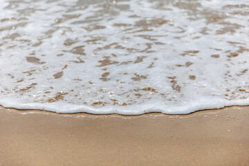 Poster - Seascape. Foam waves at sandy beach. Waterscape for background. Nature concept. Soft focus. Motion waves. Copy space.