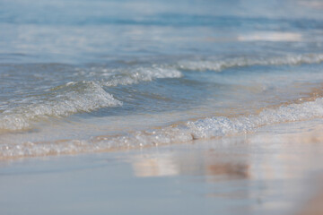 Poster - Soft wave of blue sea on sandy beach. Background. Selective focus.