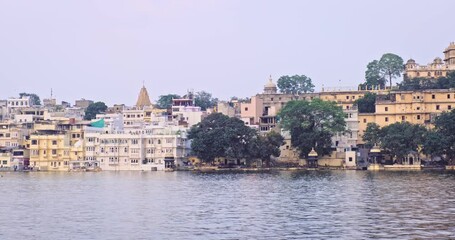 Fototapete - Udaipur Lal ghat and luxury Udaipur City Palace view over lake Pichola with tourist boat. Rajput architecture of Mewar dynasty rulers. Tourist Indian landmark. Incredible India. Horizontal camera pan