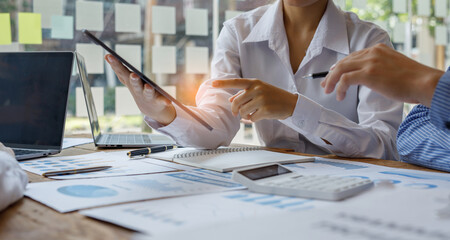 Cropped shot of diverse coworkers working together in a boardroom, working by digital tablet management big data analyze business discussing brainstorming analyzing strategy financial document 