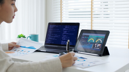 Back rear view of young asian woman, freelance data scientist work remotely at home coding programing on Big data mining, AI data engineering, IT Technician Works on Artificial Intelligence Project.