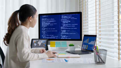 Asia young business woman sit busy at home office desk work code on desktop reskill upskill for job career remote self test IT deep tech ai design skill online html text for cyber security workforce.
