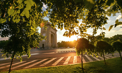 Sunrise in Bucharest with view to Arch of Triumph landmark building. Amazing color in the morning. Travel to Romania.